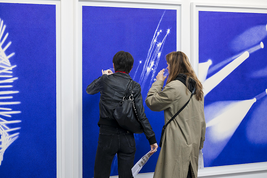 Visitors viewing blue works at Art on Paper